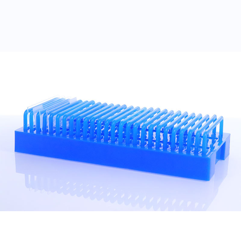 Blue 25-slide laboratory drying rack holding washed microscope slides on a bench